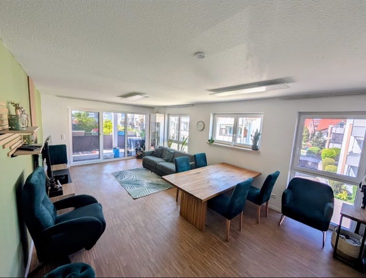 Bezugsfertiges Wohnzimmer nach einem Privatumzug: aufgebauter Esstisch, Stühle und Sofa